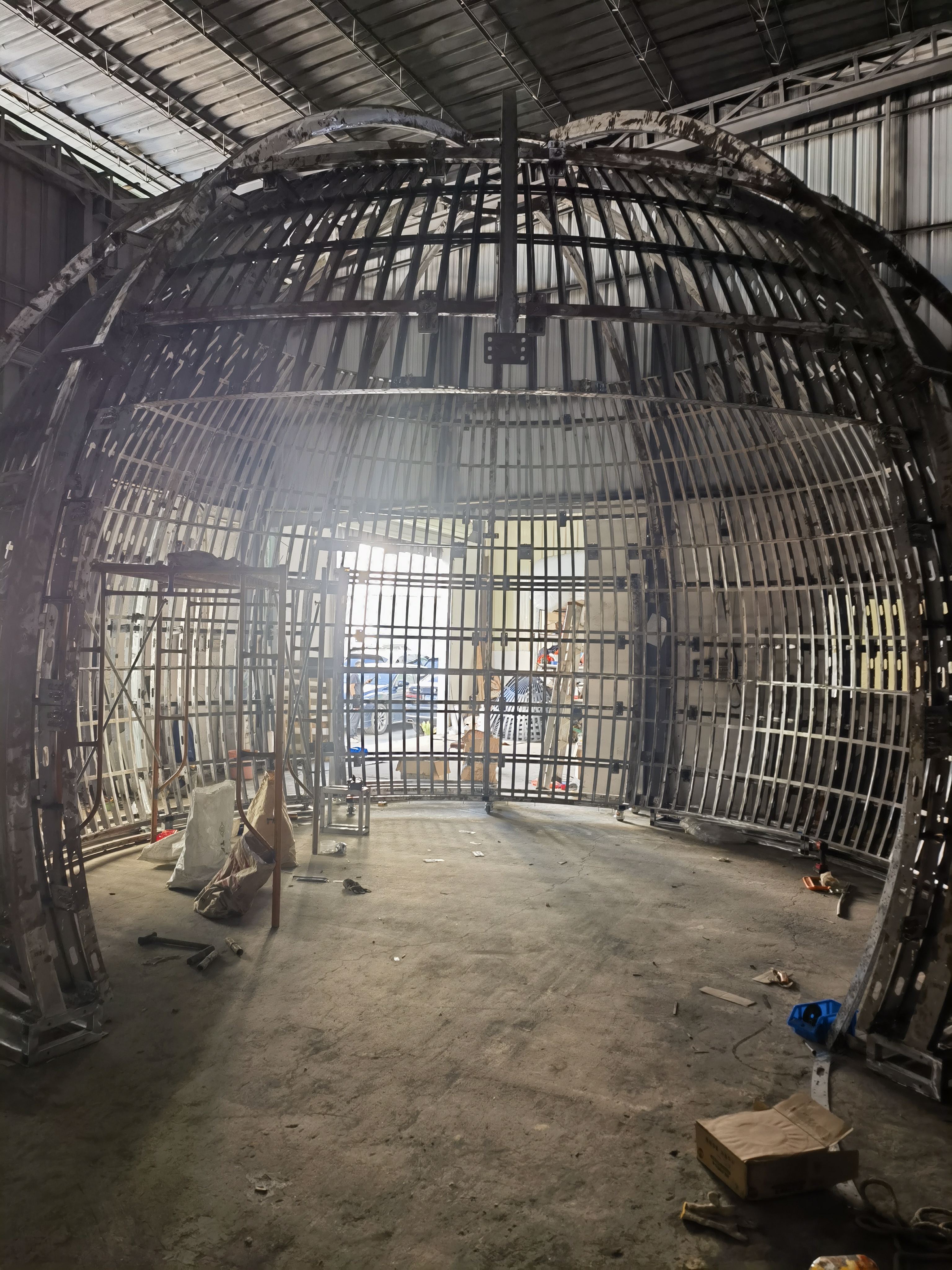 大型LED异形屏安装现场,多块弧形显示屏拼接成完整的球形屏幕,安装在商业广场中央位置